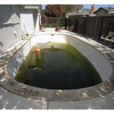 a swimming pool with green water