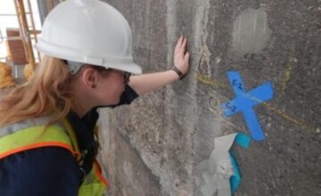 a person wearing hardhats and a hard hat painting a wall