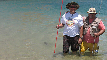 a man holding a fishing pole in the water