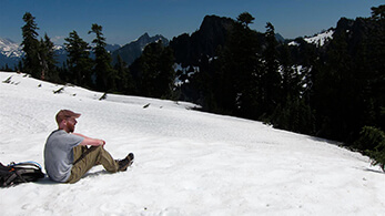 a man sitting on a snowy hill